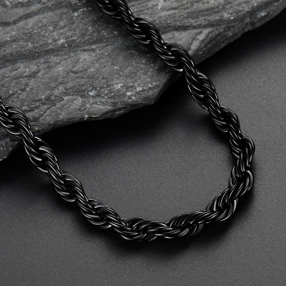 Black braided necklace on a dark surface with a stone background