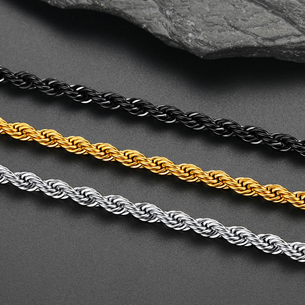 Three rope chains in black, gold, and silver on a dark surface.