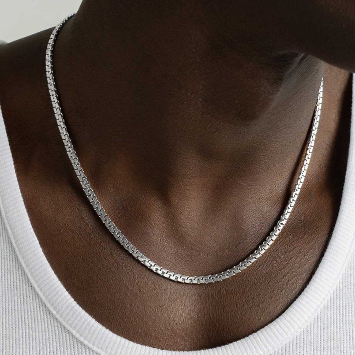 Silver necklace worn by a person with measurements displayed