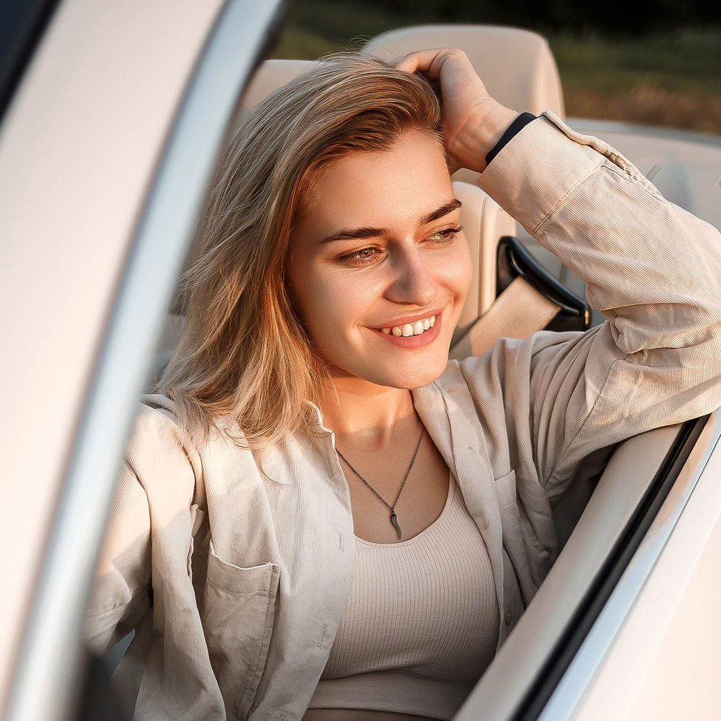 Woman in convertible wearing Cornicello Italian horn necklace