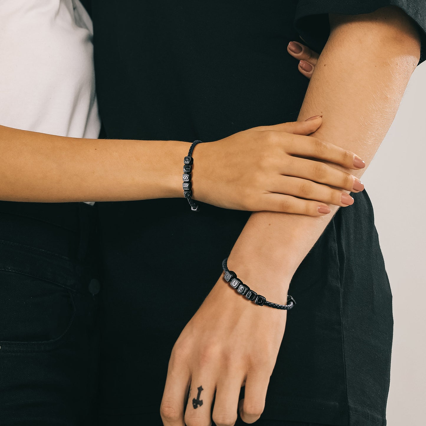Couple wearing black bracelets on their wrists.