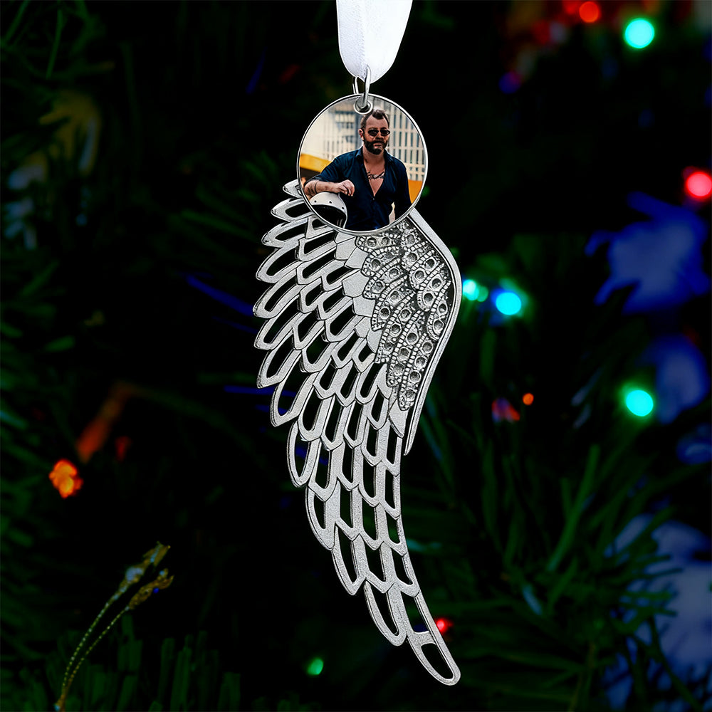 Decorative angel wing ornament with a reflective surface showing a person against a cityscape.