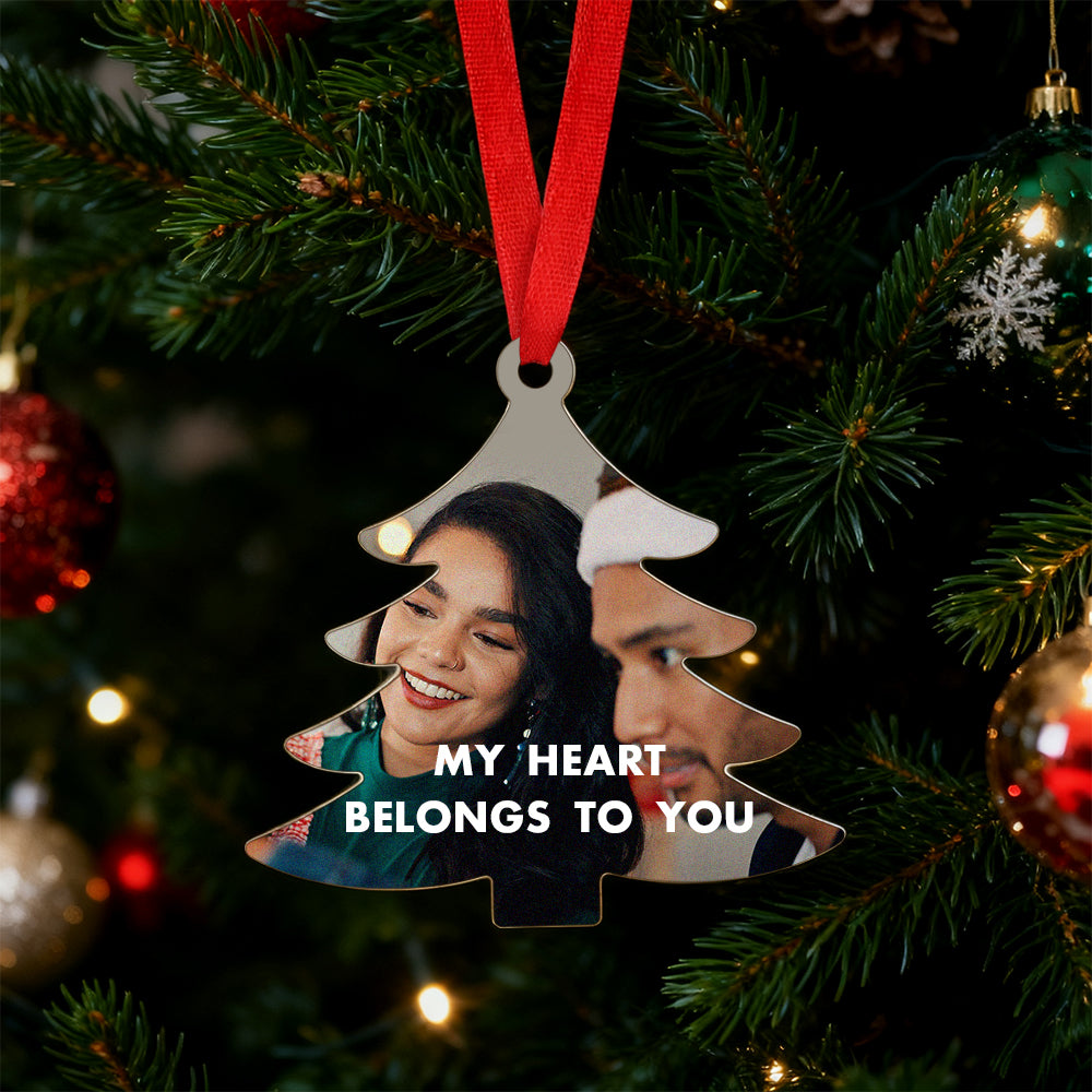 Personalized Christmas ornament with two people's faces and 'My Heart Belongs to You' text on a tree.
