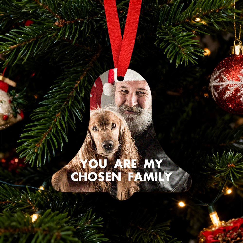 Personalized Christmas ornament with a photo of a man and a dog, hanging on a decorated tree.