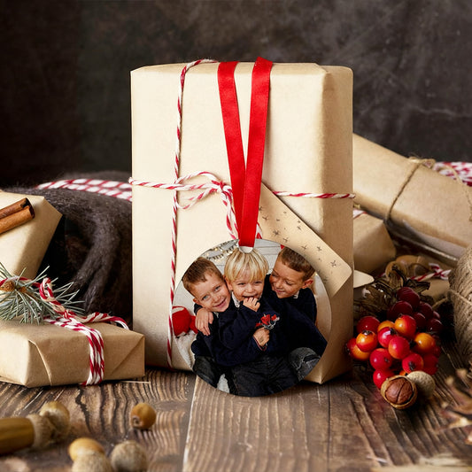 Gift box with a photo of three children on it, surrounded by Christmas decorations.