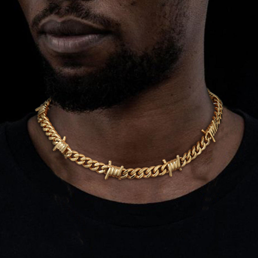 Gold barb wire Cuban link chain necklace on a man