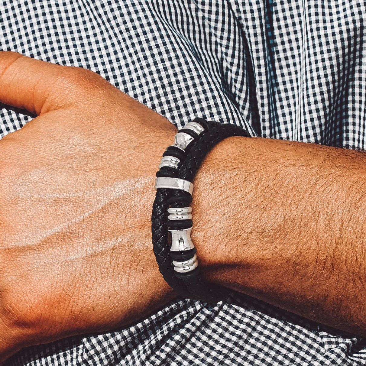 Man wearing black braided leather bracelet cuff