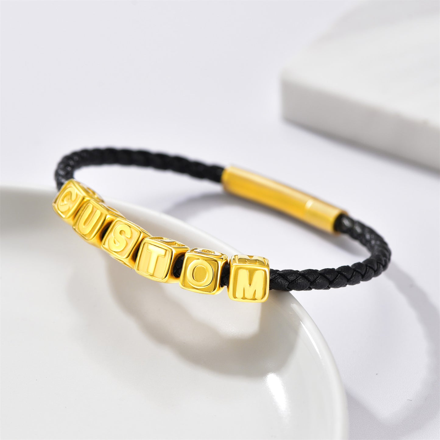 Black braided bracelet with gold beads labeled 'CUSTOM' on a white background