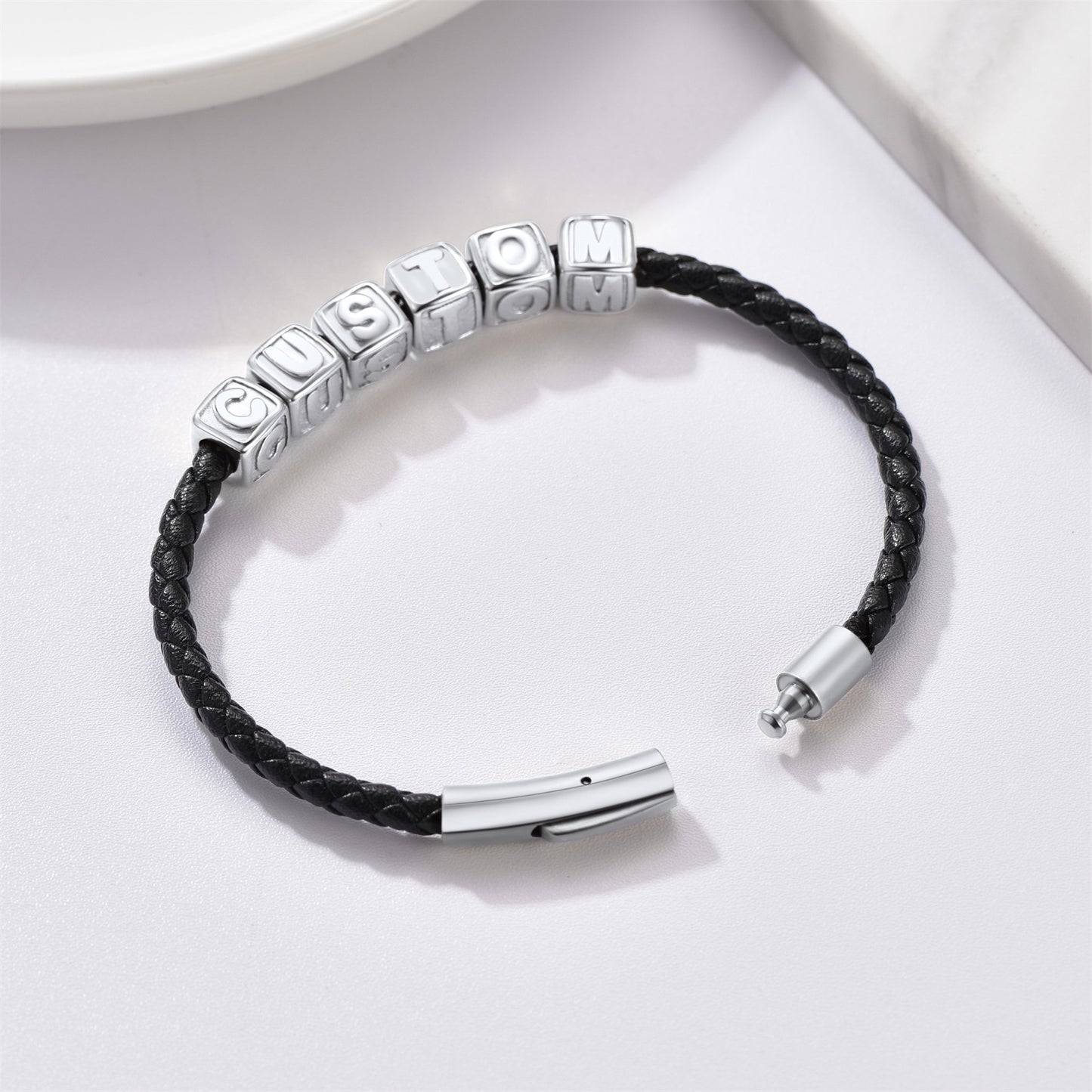 Black leather bracelet with silver beads on a white background