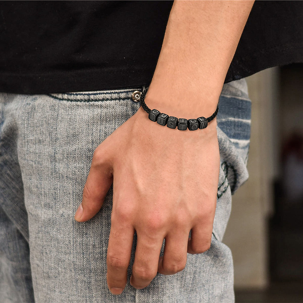 Person wearing a black beaded bracelet on a blurred background