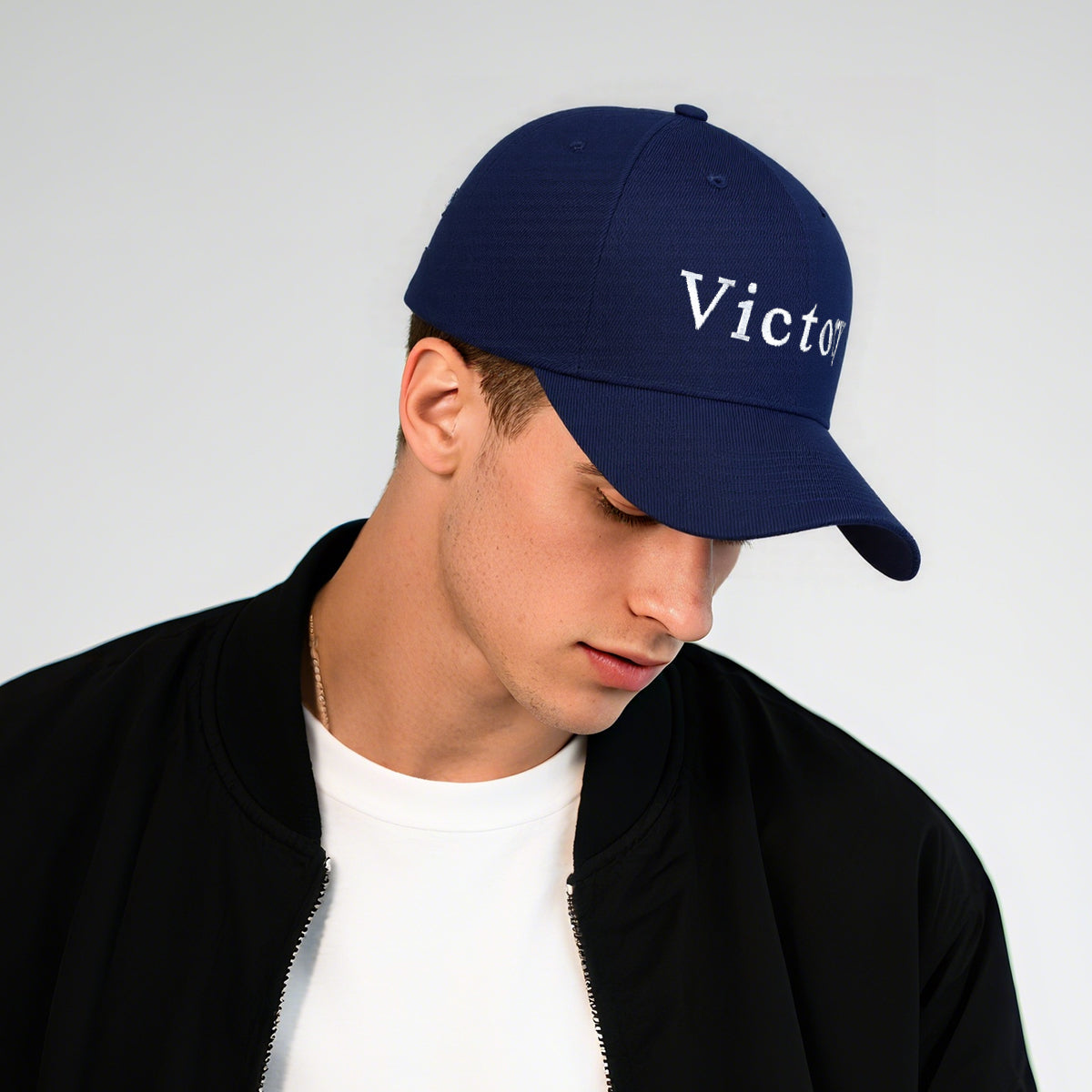 Person wearing a navy blue cap with 'Victory' text on a light gray background