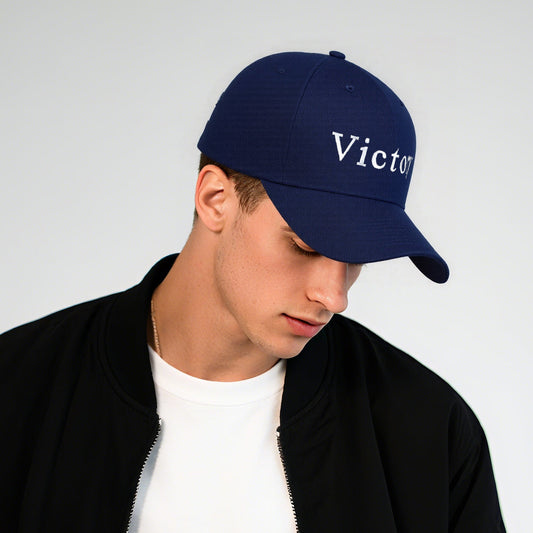 Person wearing a navy blue cap with 'Victory' text on a light gray backgroundimg