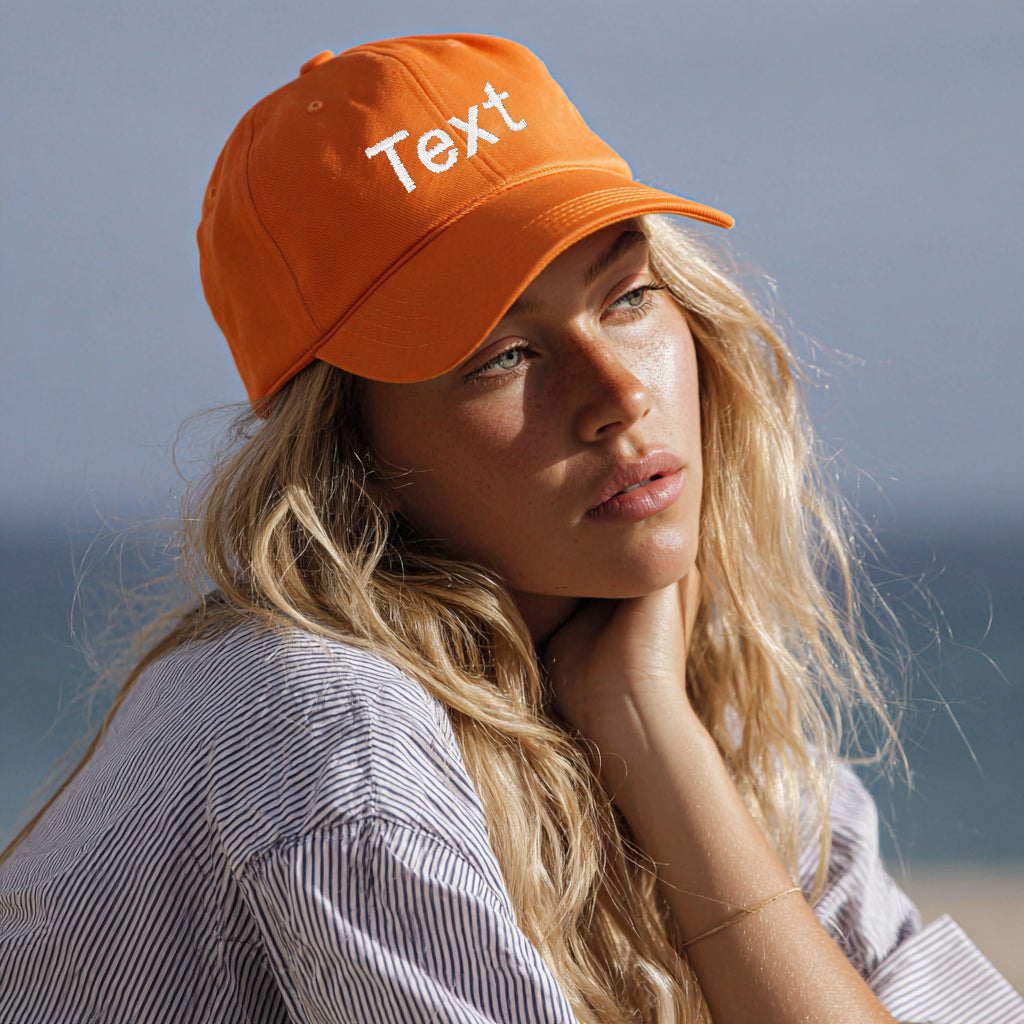 Woman wearing an orange cap with 'Text' on it against a clear sky.