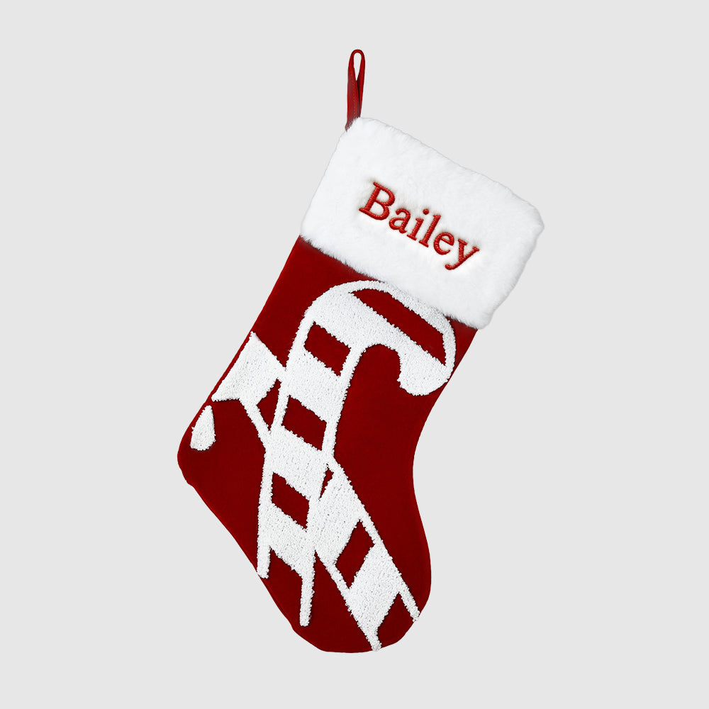 Red and white Christmas stocking with a dog design and 'Bailey' text on a light gray background