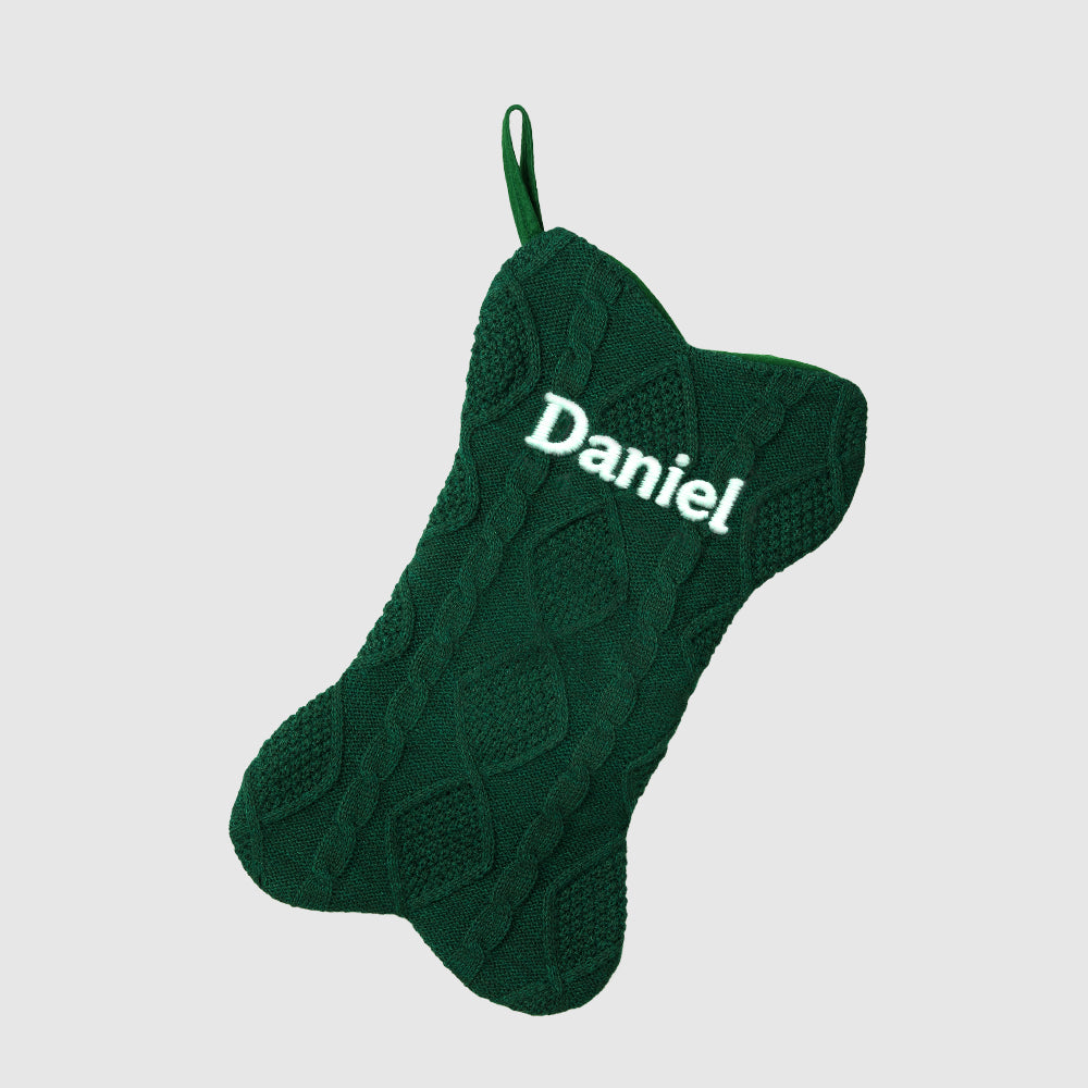 Green knitted stocking with 'Daniel' embroidered on a light gray background