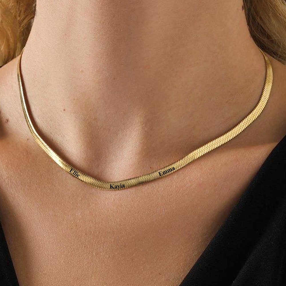 Gold necklace with engraved names on a person's neck