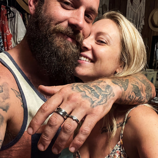 Couple wearing matching his and hers personalized promise rings on finger