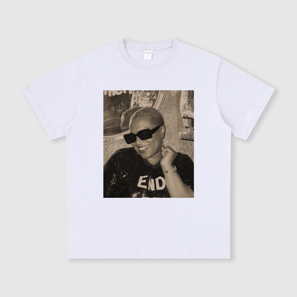 White t-shirt with a printed photo of a person wearing sunglasses and a cap on a light gray background