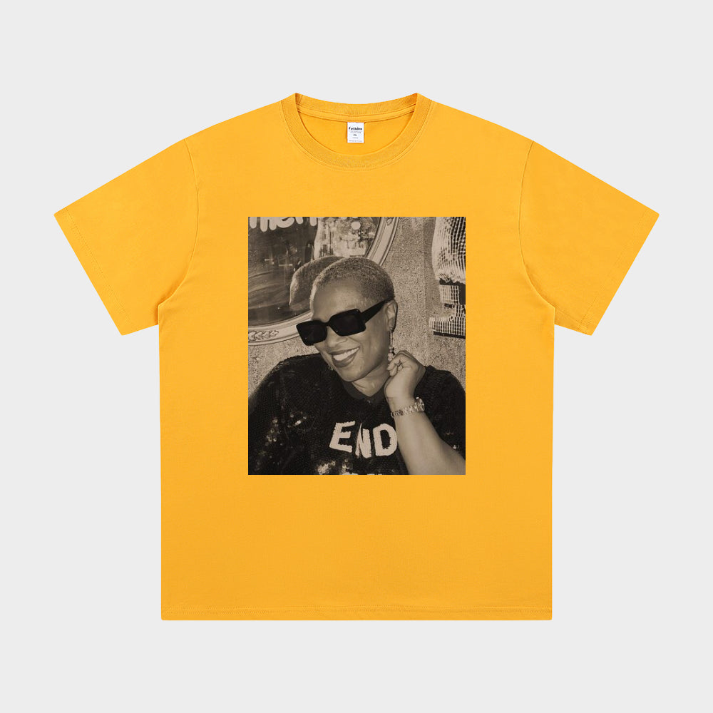 Yellow t-shirt with a graphic of a person wearing sunglasses and a cap on a white background