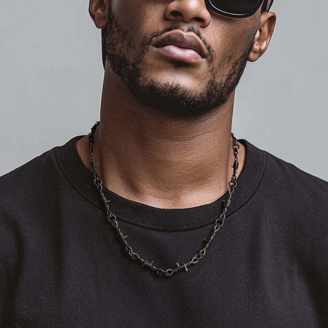 Man wearing a black shirt and sunglasses with a gray background