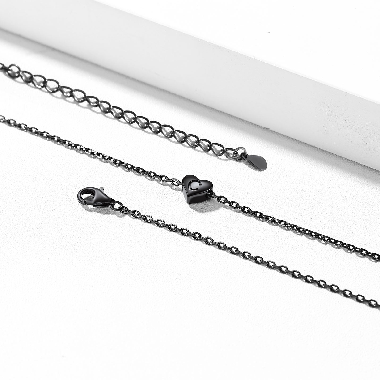 Black chain necklace with heart clasp on a white background