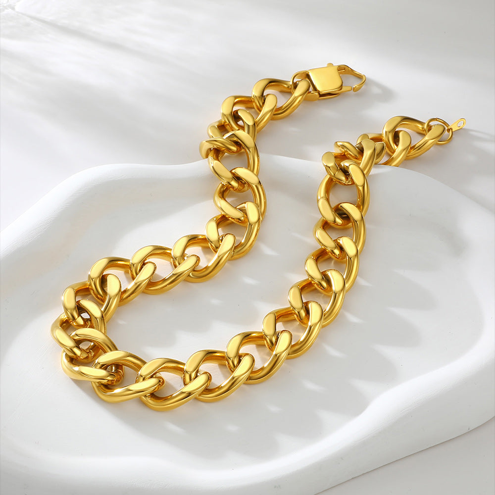 Gold chain bracelet on a white fabric background