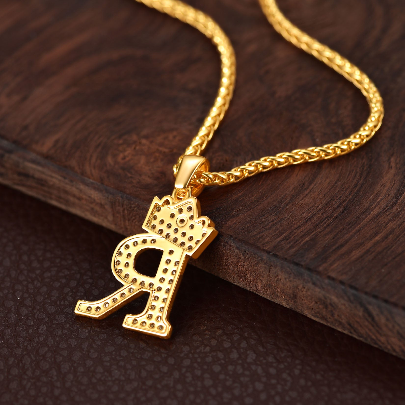 Gold necklace with a unique pendant on a wooden surface