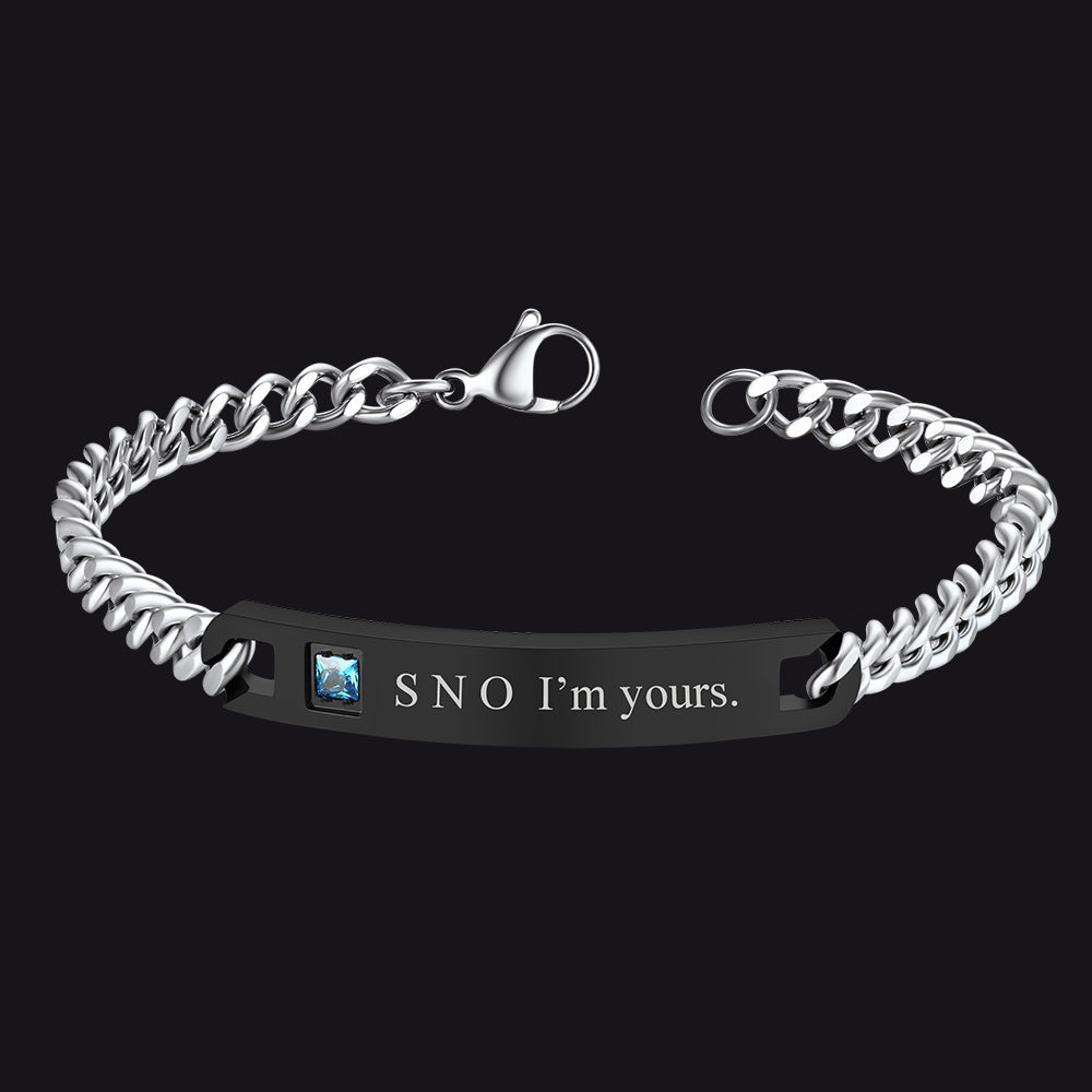 Silver chain bracelet with engraved message on a black background