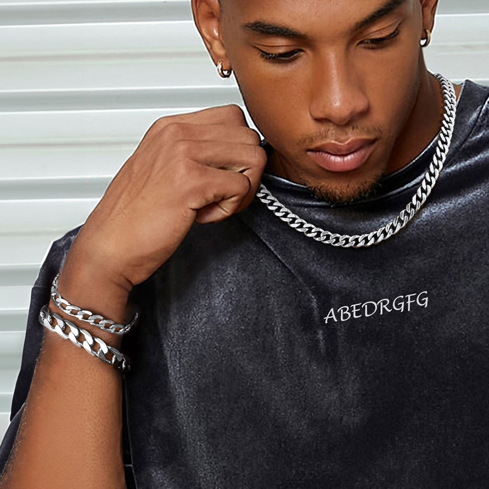 Man wearing a dark gray sweatshirt , accessorized with silver chains and bracelets.