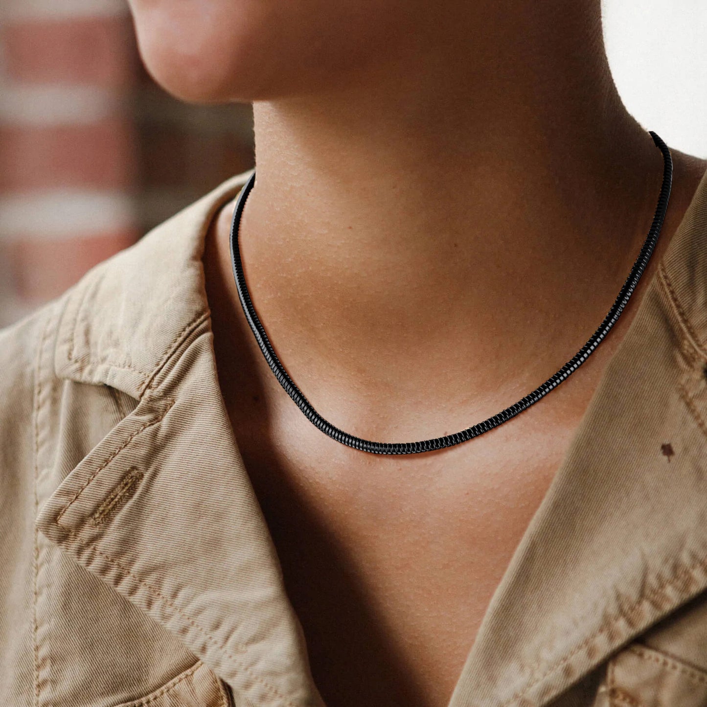 Female model styling silver 5mm snake chain necklace with minimalist outfit
