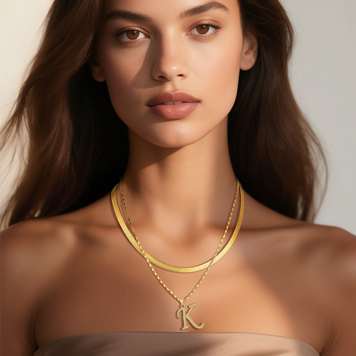 Layered initial necklaces in gold and silver tones for women.