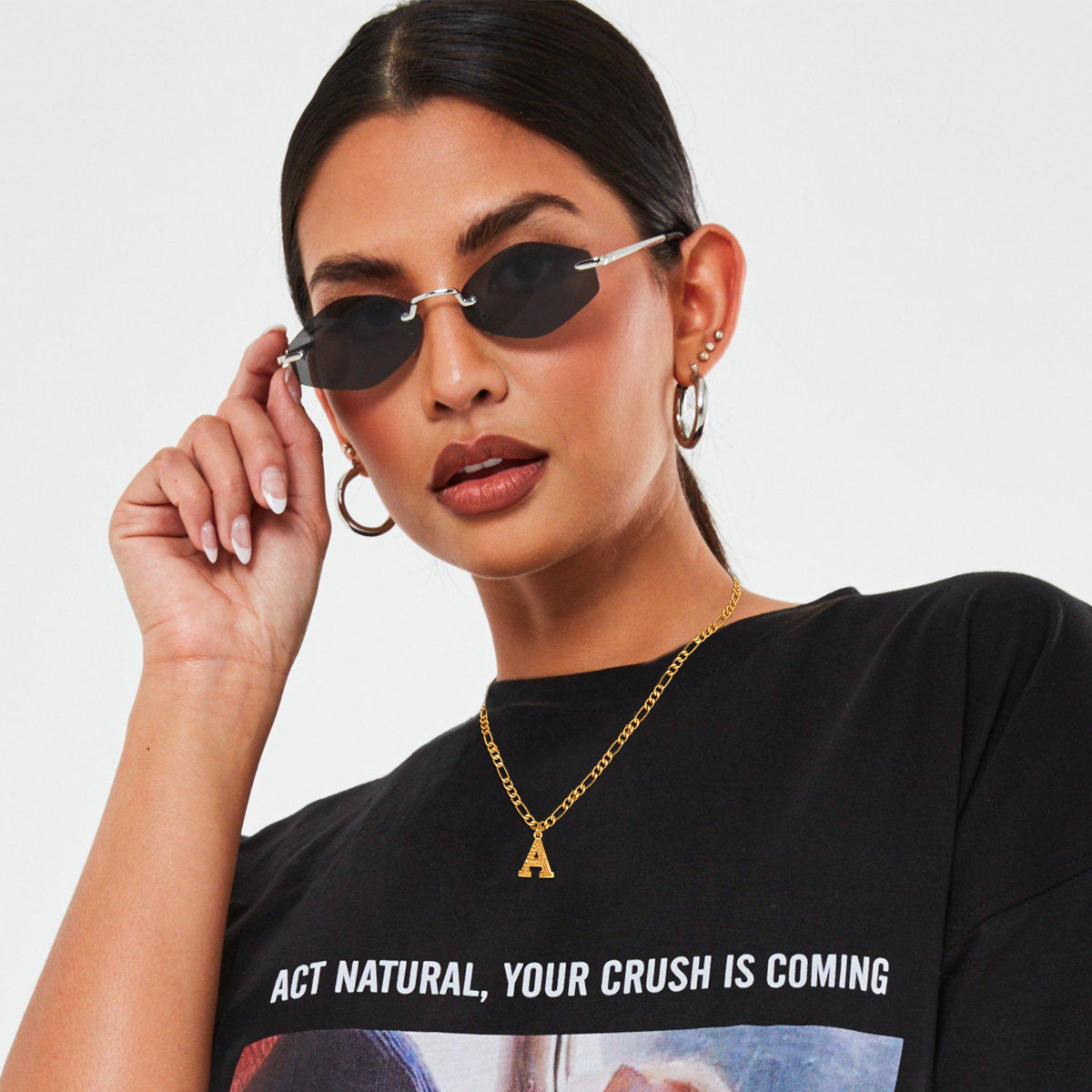 Female model styling an initial choker necklace with layered chains
