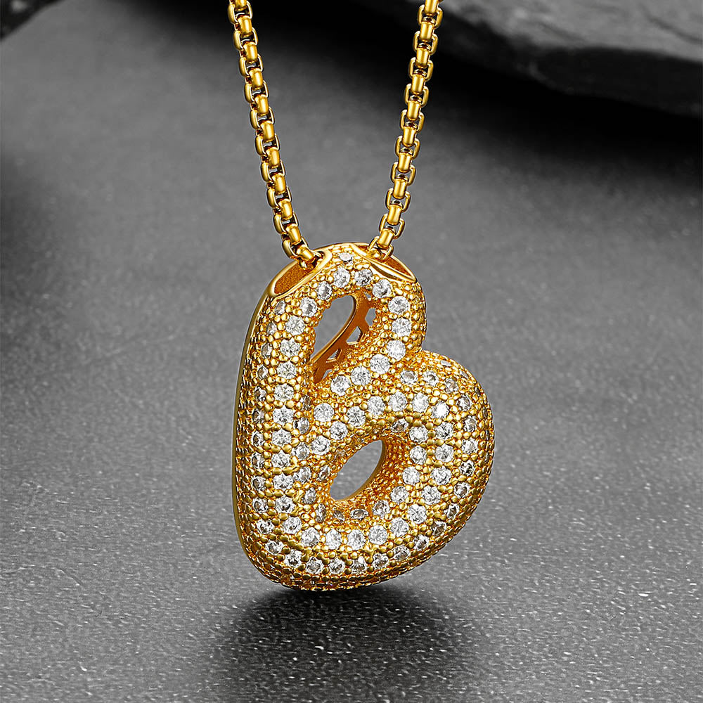 Gold initial necklace with cubic zirconia on black velvet