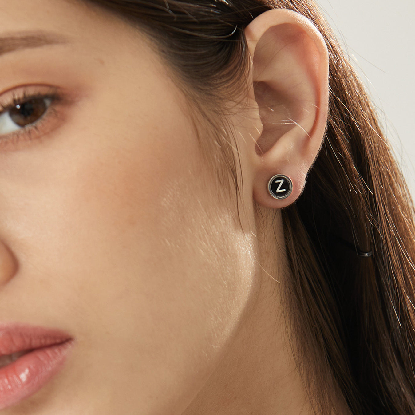 Black enamel initial stud earring with letter Z on ear