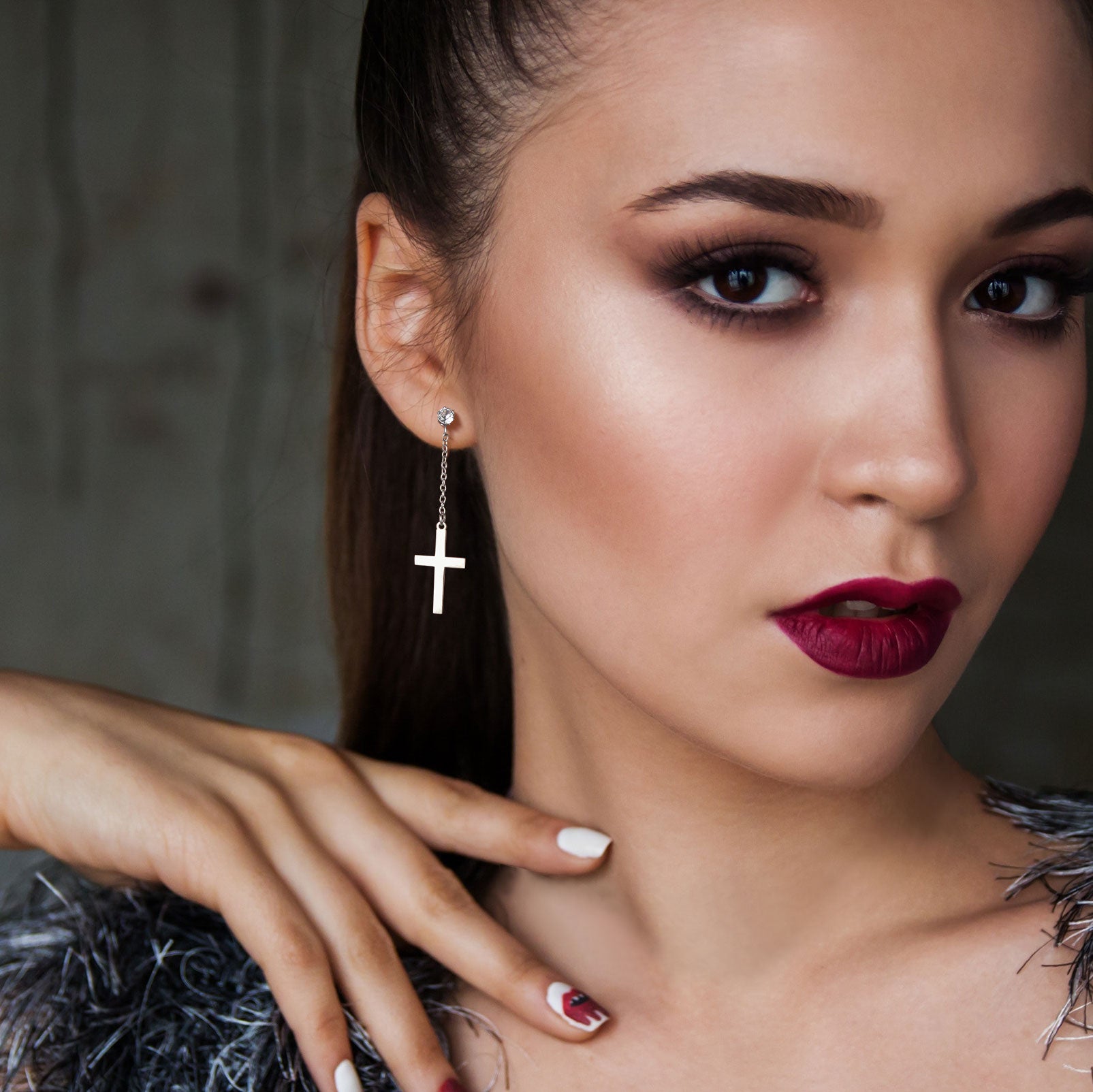 Woman wearing asymmetric cross dangle earrings