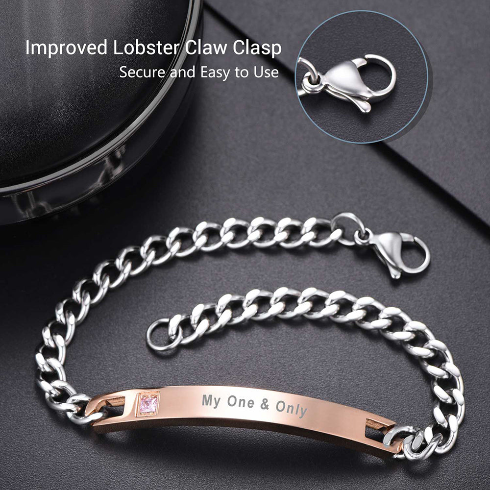 Silver chain bracelet with rose gold tag and 'My One & Only' engraving on a dark surface.