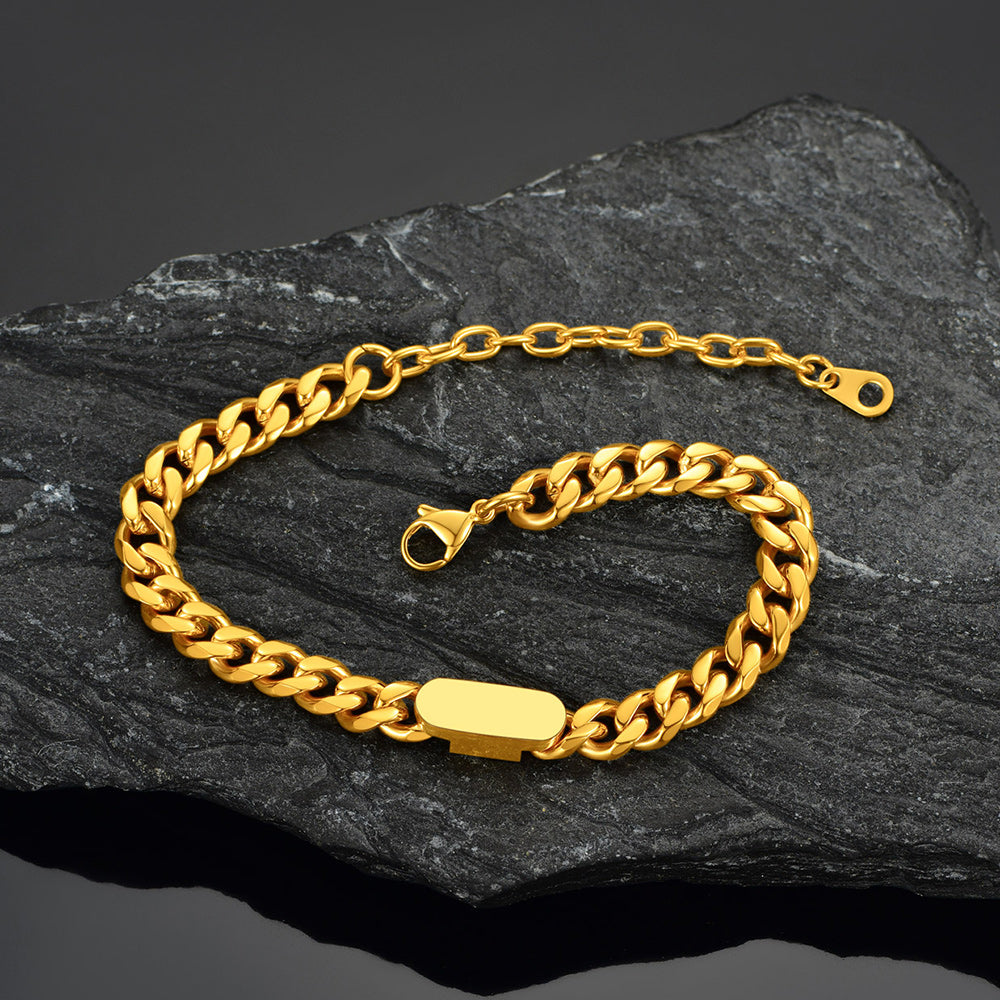Gold chain bracelet on a dark stone surface