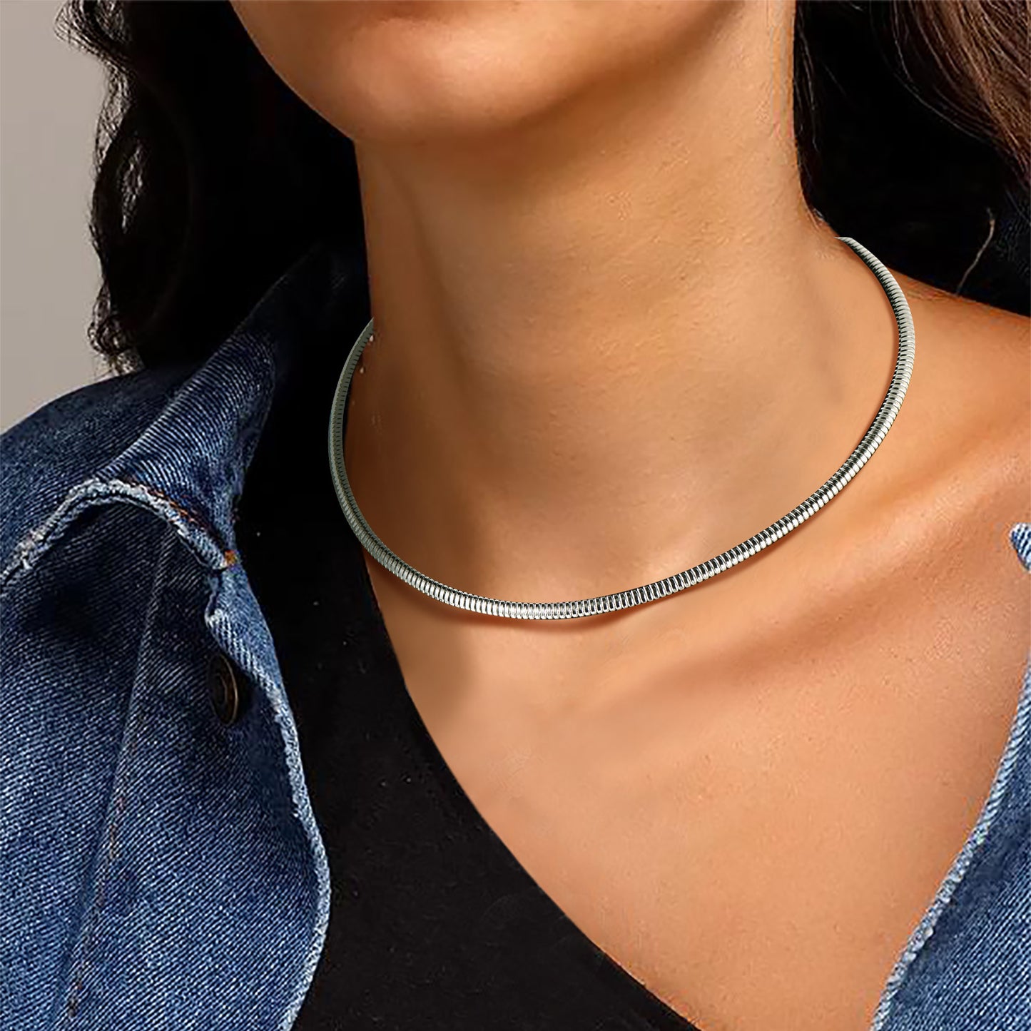 Woman wearing steel herringbone chain necklace layered with pendant for a chic look