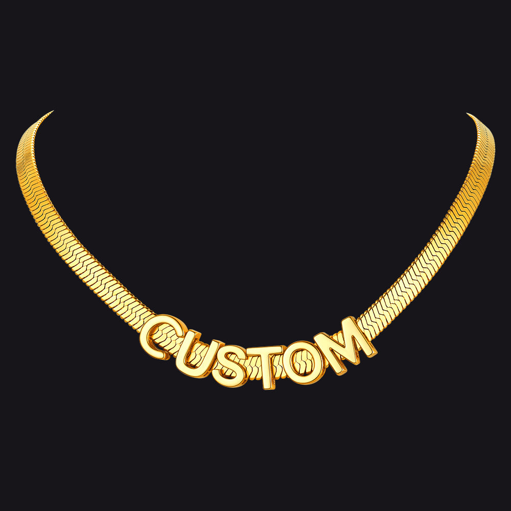 Gold necklace with 'CUSTOM' engraved on a black background