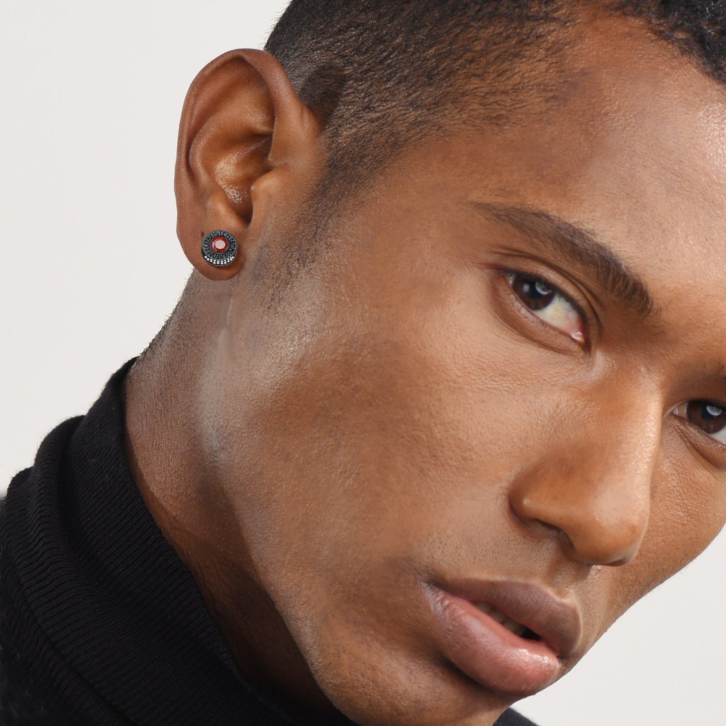 Close-up of a person wearing a black turtleneck with a neutral background