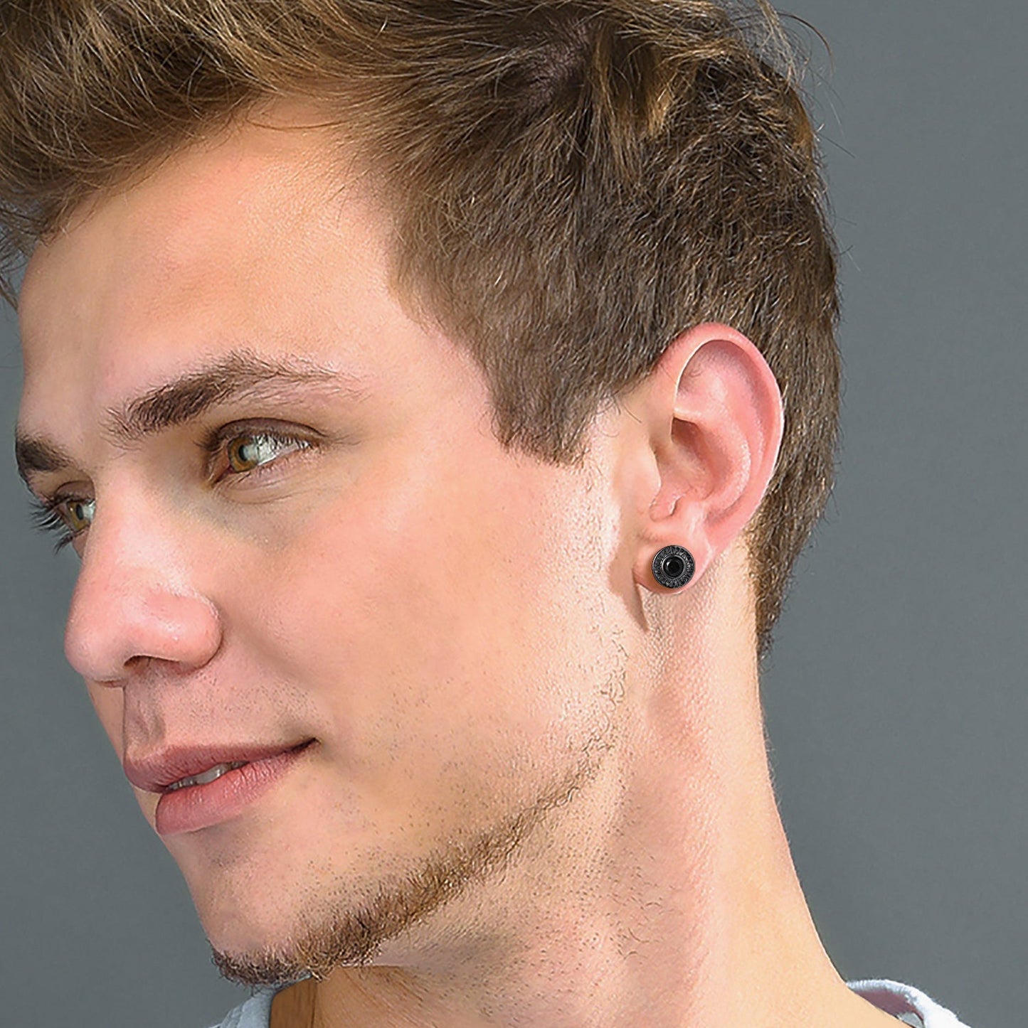 Man wearing a black earring on a gray background
