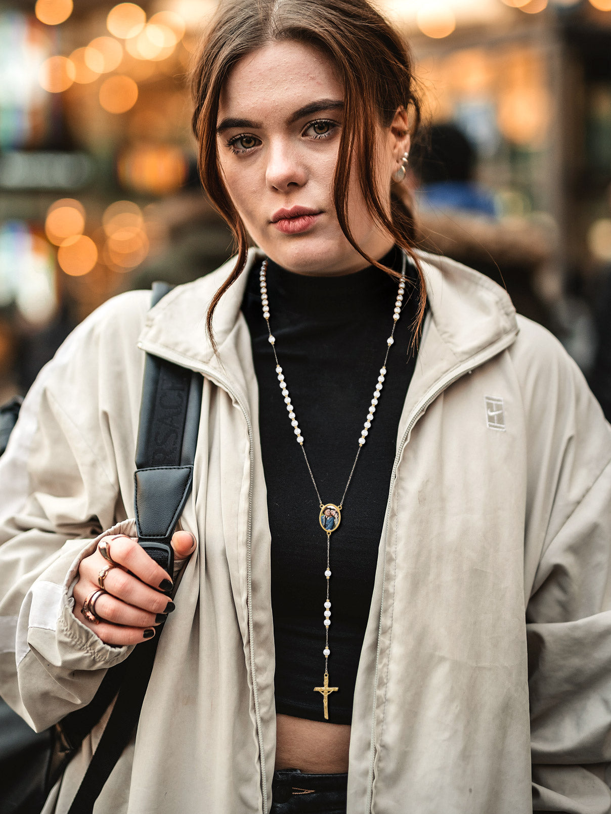 Woman wearing pearl rosary beads necklace with cross pendant