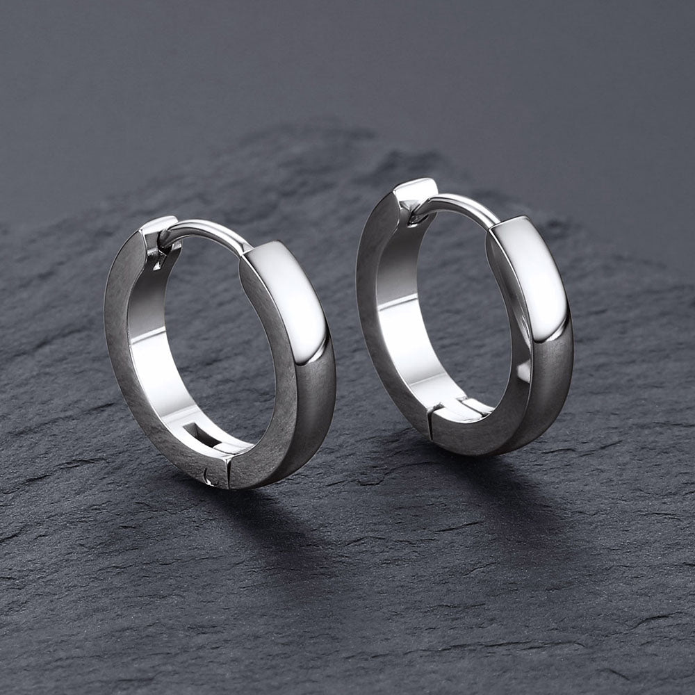 Pair of silver hoop earrings on a dark gray surface