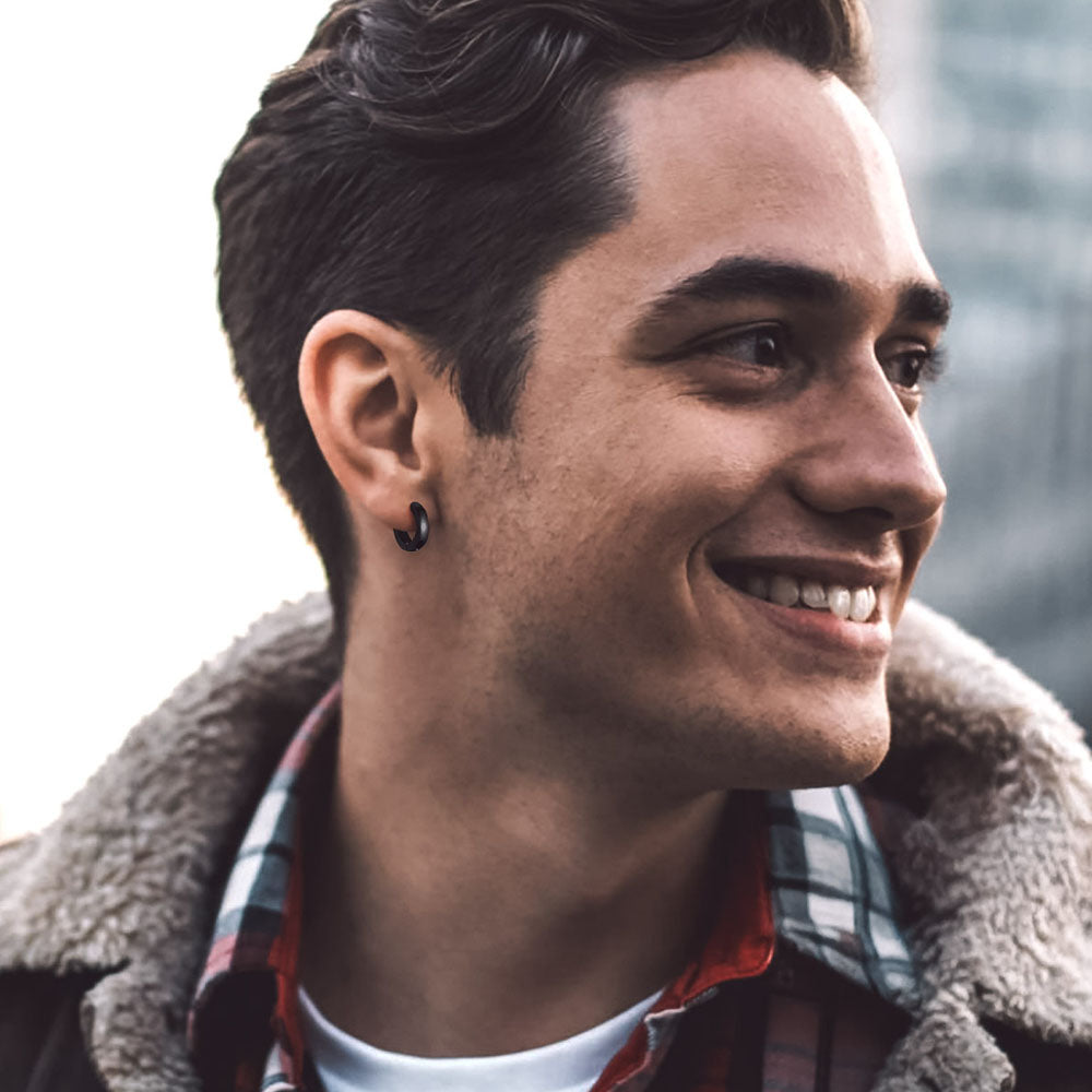 Man wearing a plaid shirt and brown coat with a blurred background