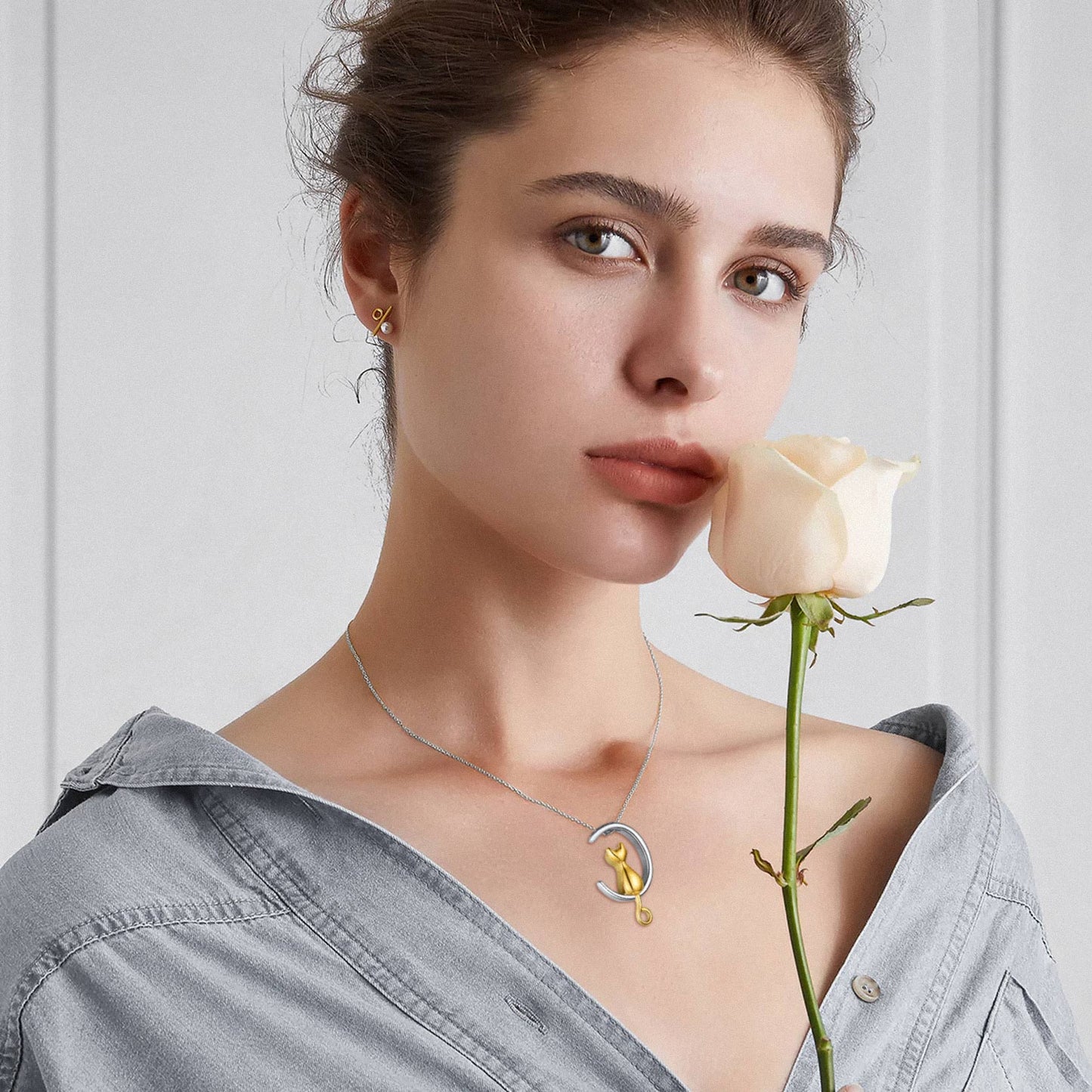 Woman wearing gold cat urn necklace close to heart as pet memorial