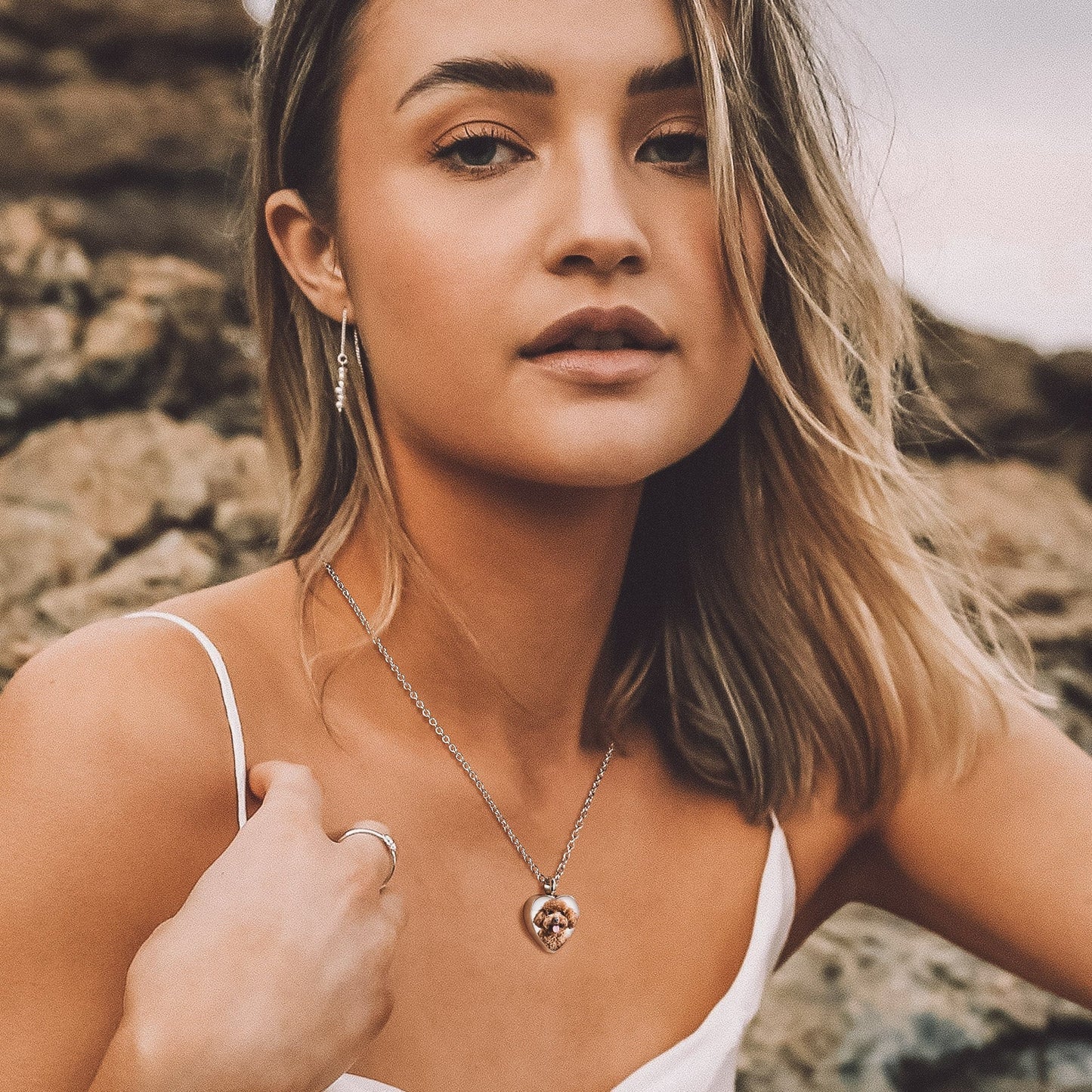 Woman wearing steel heart-shaped urn photo necklace for remembrance