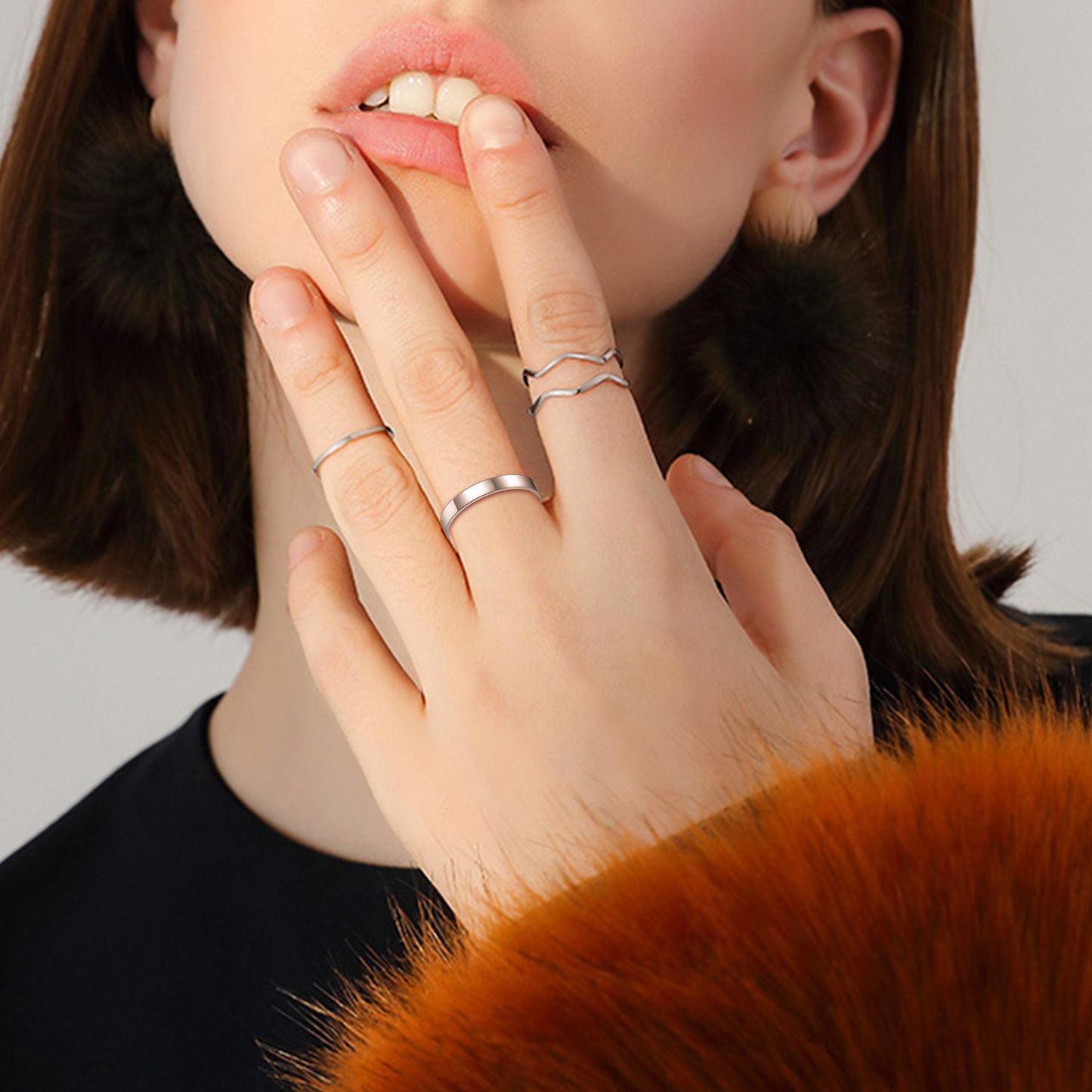 Woman wearing sterling silver band ring and other rings, fashion jewelry