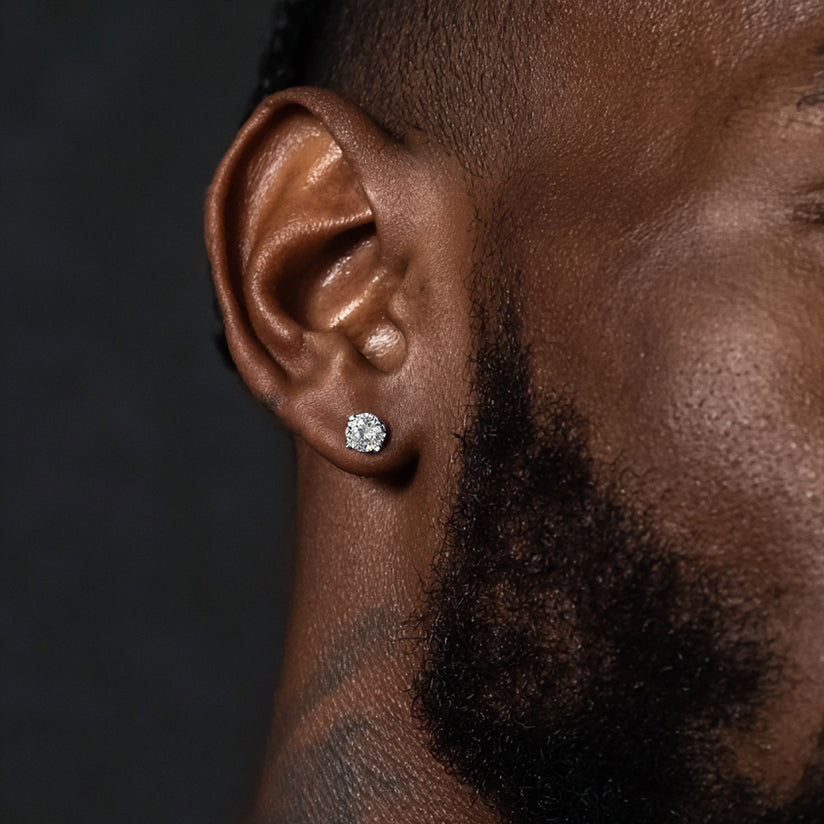 Close-up of a man wearing a diamond earring with a dark background