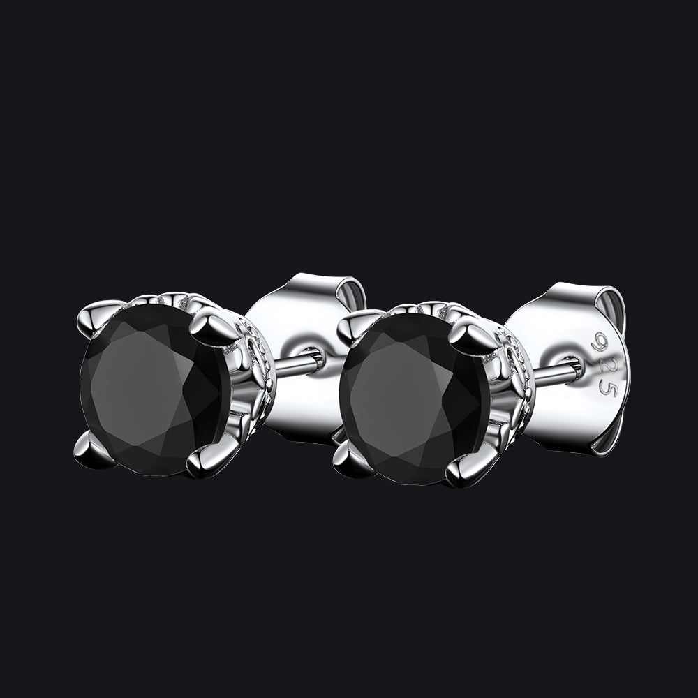 Silver stud earrings with black gemstones on a black background