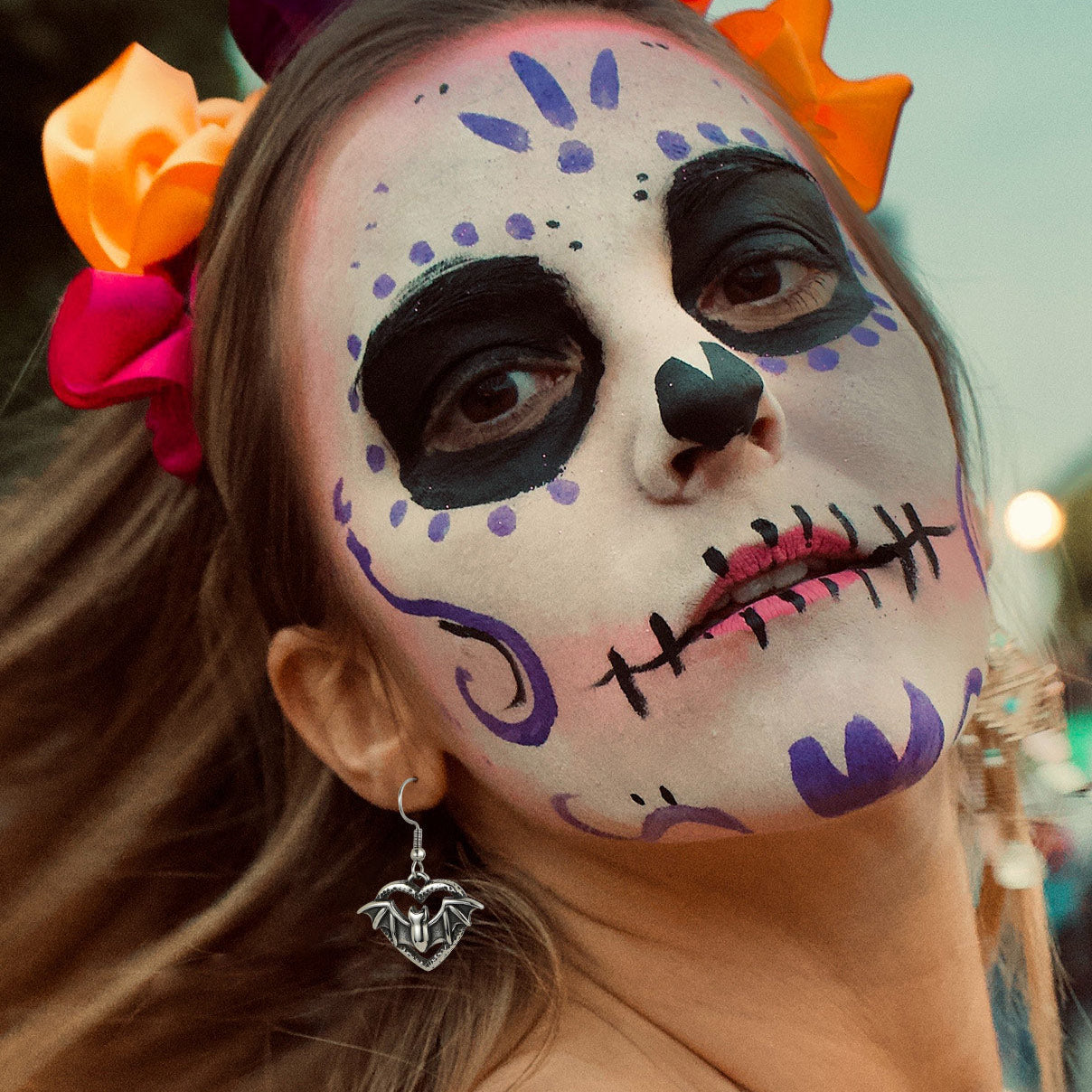 Person with Day of the Dead face paint and colorful headpiece